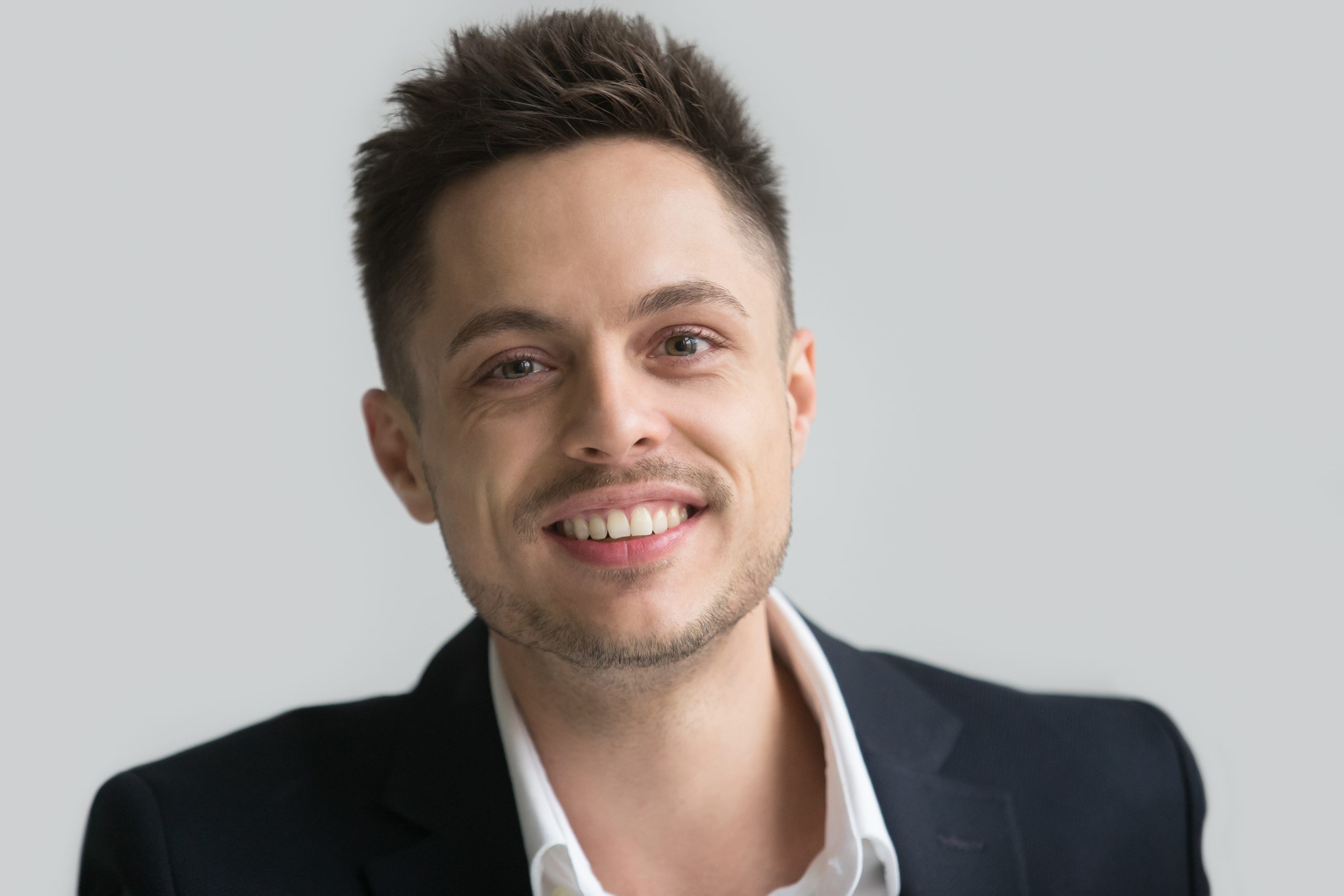 Portrait of happy businessman in smart suit smiling at camera posing for company advertising catalogue. Student shooting for academic album having photosession. Concept of confidence, positive spirit